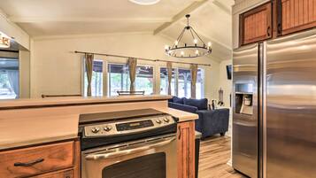 A modern kitchen with a stainless steel refrigerator, a built-in oven, and a wooden countertop.