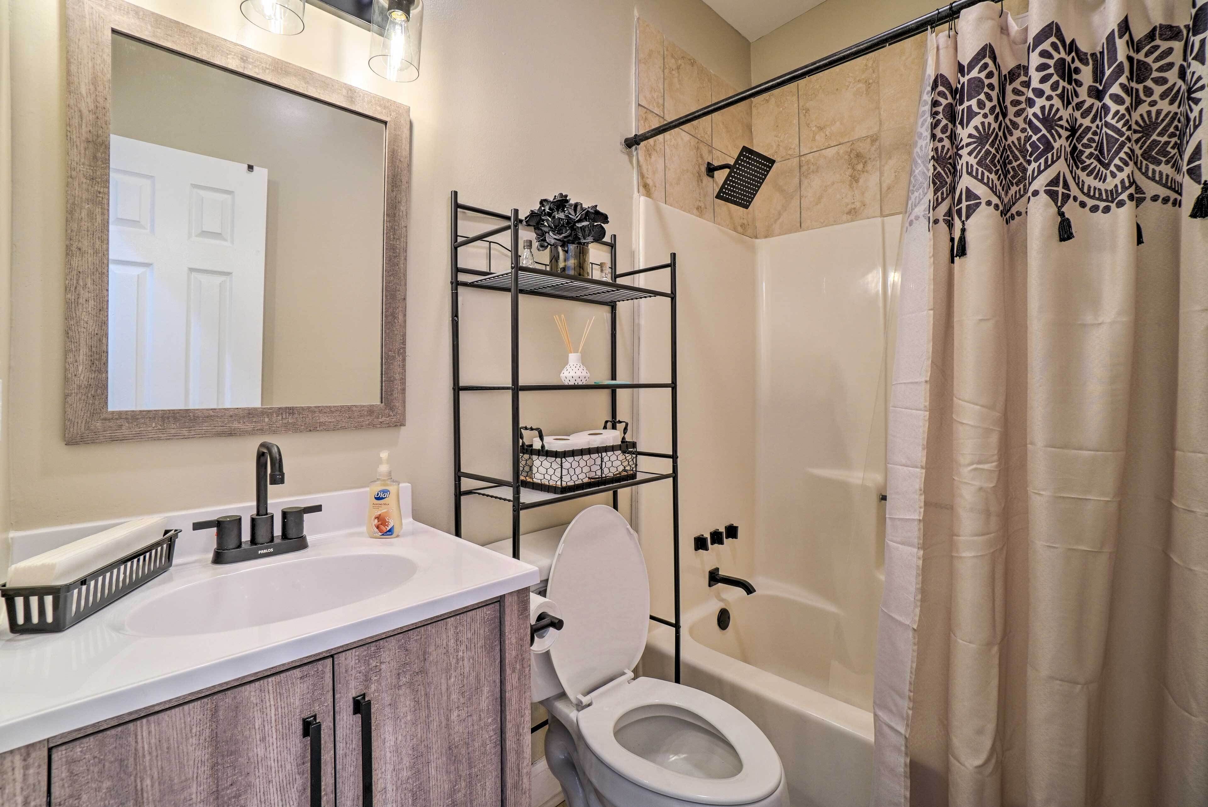 A bathroom with a white sink, a toilet, a shower with a glass door, and a mirror above the sink.