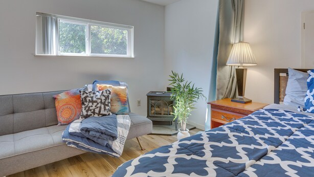 A bedroom with a bed, a sofa, a lamp, a plant, and a window. - Bright & Airy Seattle Abode < 9 Mi to Space Needle (Seattle)