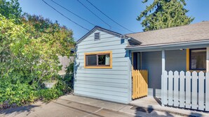 A small, light blue house with a white picket fence, a wooden door, and a window with a yellow frame. - Bright & Airy Seattle Abode < 9 Mi to Space Needle (Seattle)