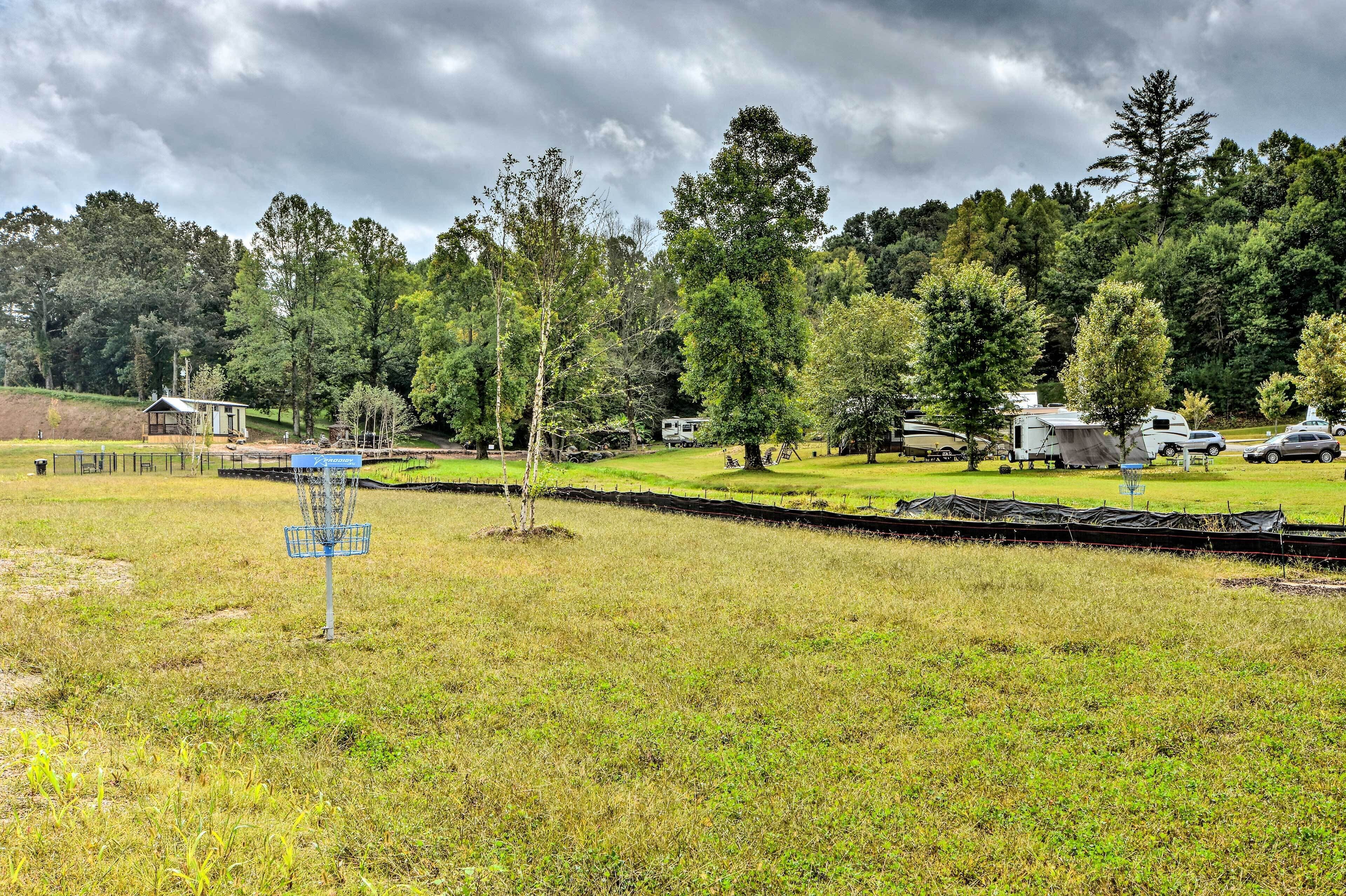 A campground with RVs, a disc golf course, and a small cabin.
