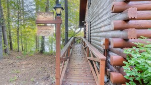 A wooden staircase leading to a log cabin with a sign reading "Welcome to Larders Landing."