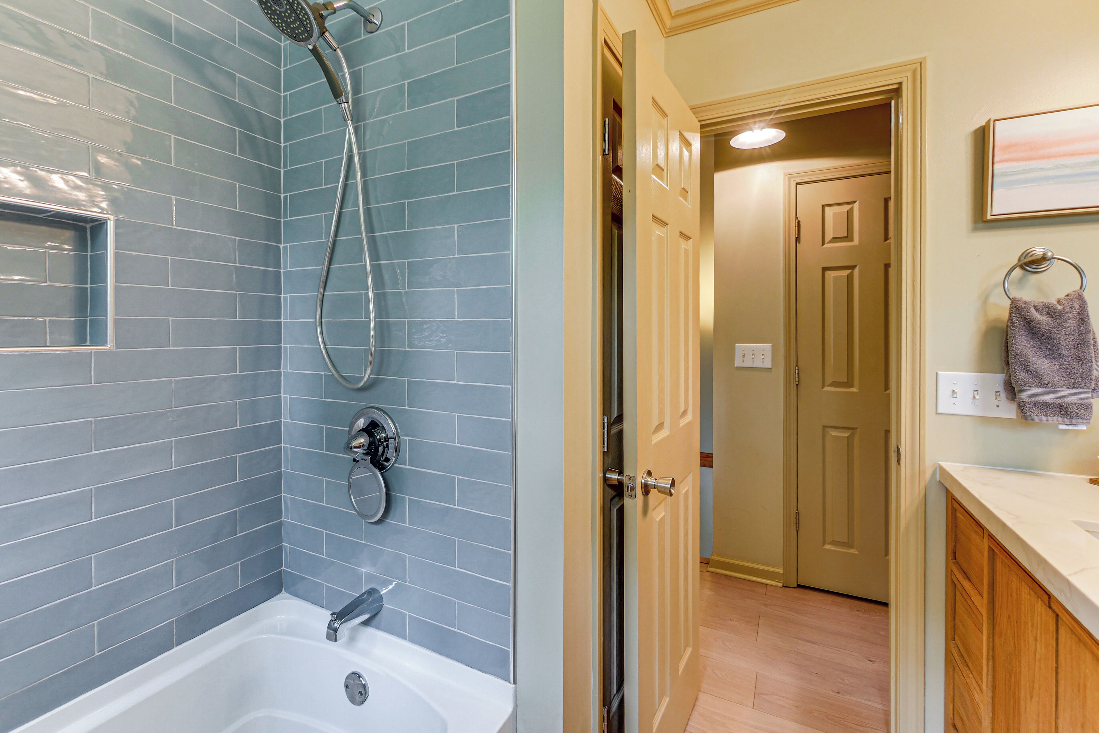 A bathroom with a bathtub, shower, and tiled walls.