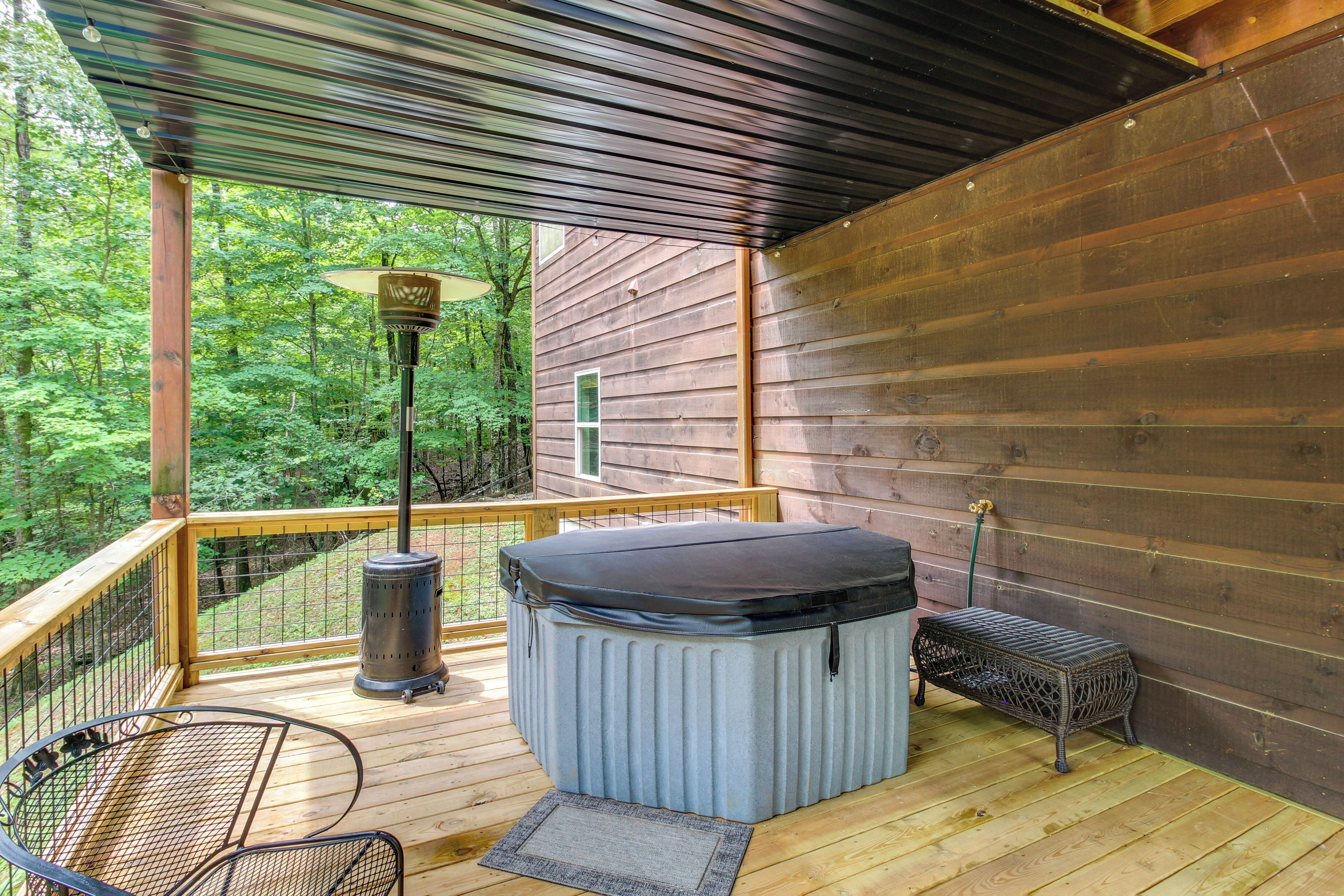Une terrasse en bois avec un jacuzzi, une table et un banc.