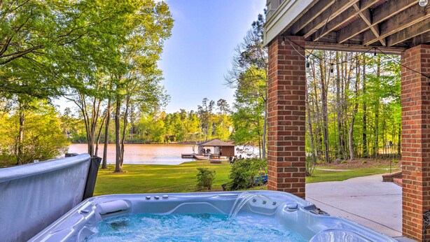 Un jacuzzi con vistas a un lago y árboles.