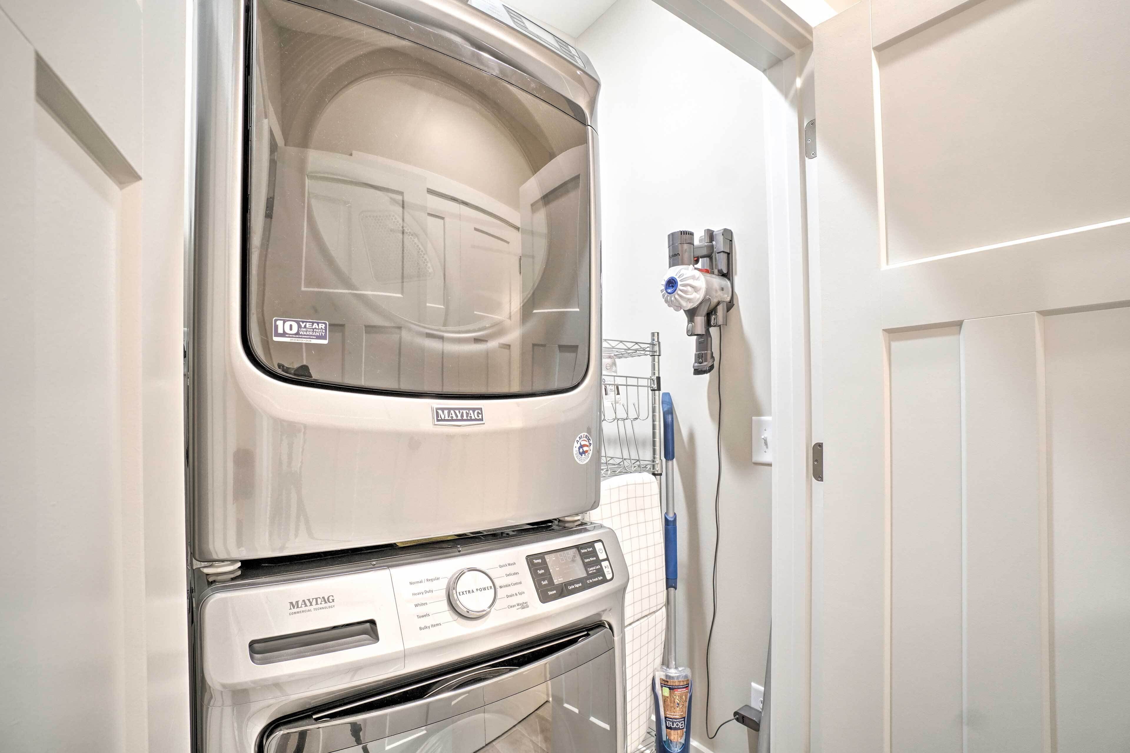 Un juego de lavadora y secadora Maytag para uso comercial, con una etiqueta que indica garantía de 10 años, en una habitación con paredes blancas.