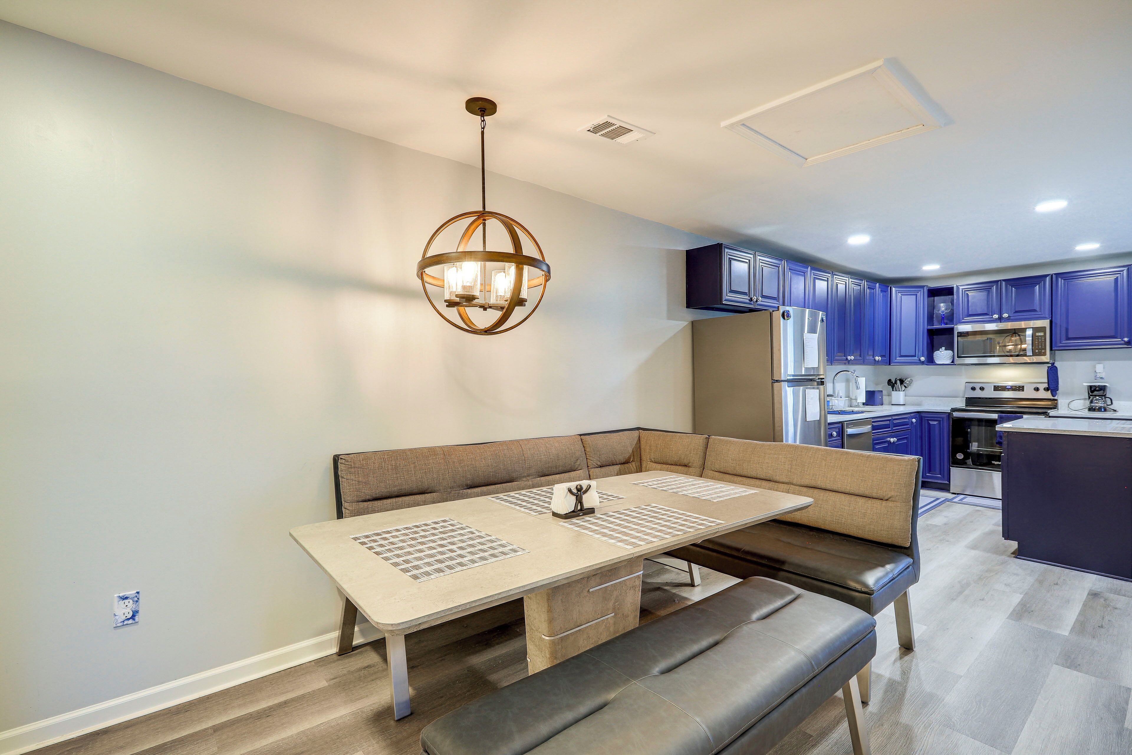 A modern kitchen with dark blue cabinets, stainless steel appliances, and a central island.