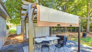 A covered patio area with a table and chairs, a pergola structure, and a patterned rug. - Conyers Vacation Rental w/ Pool: 5 Mi to Olde Town (Conyers)