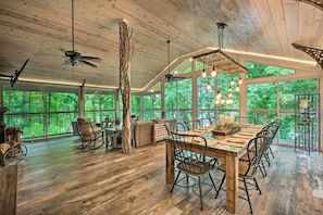 A spacious dining area with a long wooden table, chairs, and hanging lights. - Hiawassee Getaway w/ Hot Tub, Deck & Lake Access! (Hiawassee)