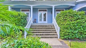 Stroll up to the charming entrance of this inviting home, surrounded by lush greenery and beautifully manicured bushes.