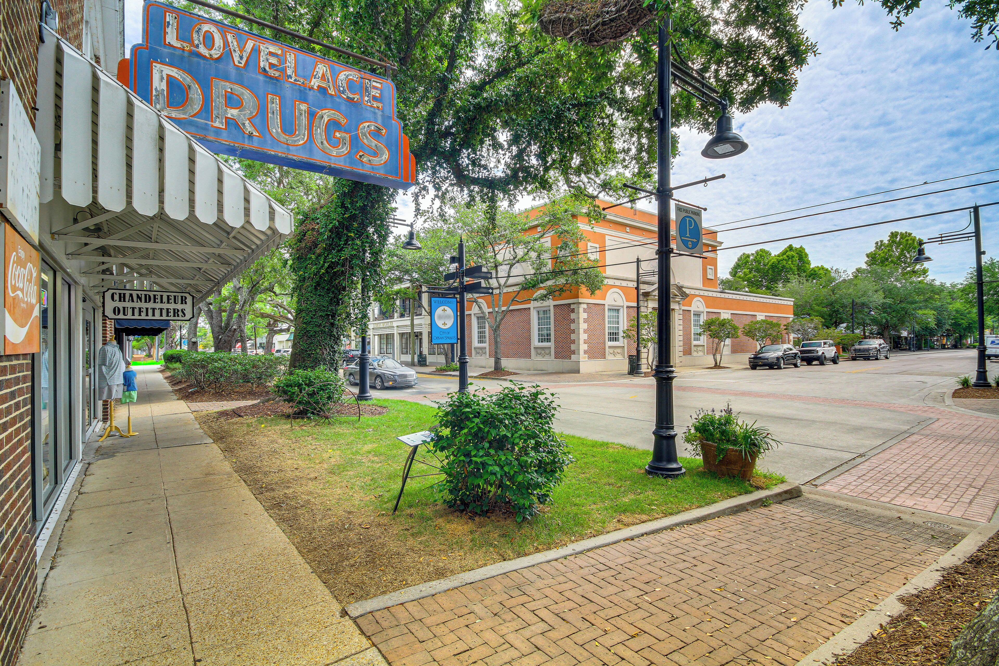 A storefront with a sign reading "LOVELACE DRUGS" and a "CHANELLEUR OUTFITTERS" sign below.