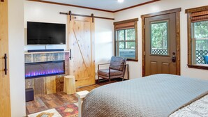 A bedroom with a bed, a TV mounted on the wall, a sliding door, and a window with a view of trees. - Game Room, Mtn Views! Unit 1 Mi to Heavenly Resort (Stateline)