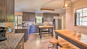 Une cuisine moderne avec des meubles en bois foncé, des plans de travail en granit et un îlot central.