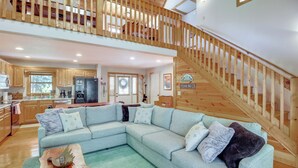 A spacious living area with a light-colored sectional sofa, a wooden coffee table, and a staircase with a wooden railing. - Coosawattee River Resort Home Mins From Blue Ridge (Ellijay)
