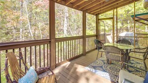 A covered outdoor deck with wooden railings, a table with chairs, and a ceiling fan. - Coosawattee River Resort Home Mins From Blue Ridge (Ellijay)