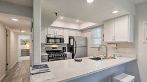 A modern kitchen with white cabinetry, stainless steel appliances, and a large island with bar stools. - < 1 Mi to Slopes! 'heavenly Daze Chalet' in Tahoe (Stateline)