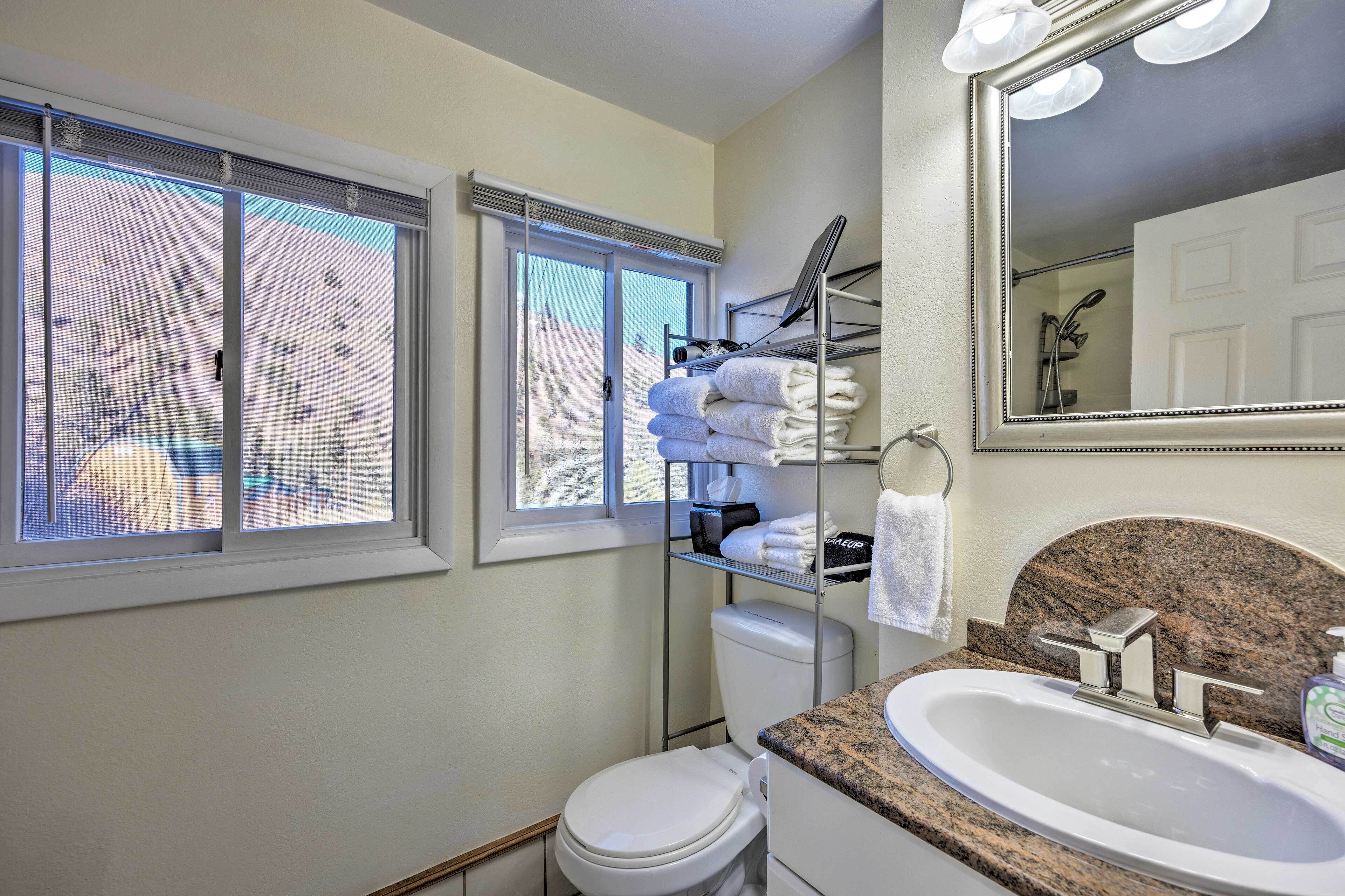 Une salle de bain équipée de toilettes, d’un lavabo et d’un porte-serviettes.