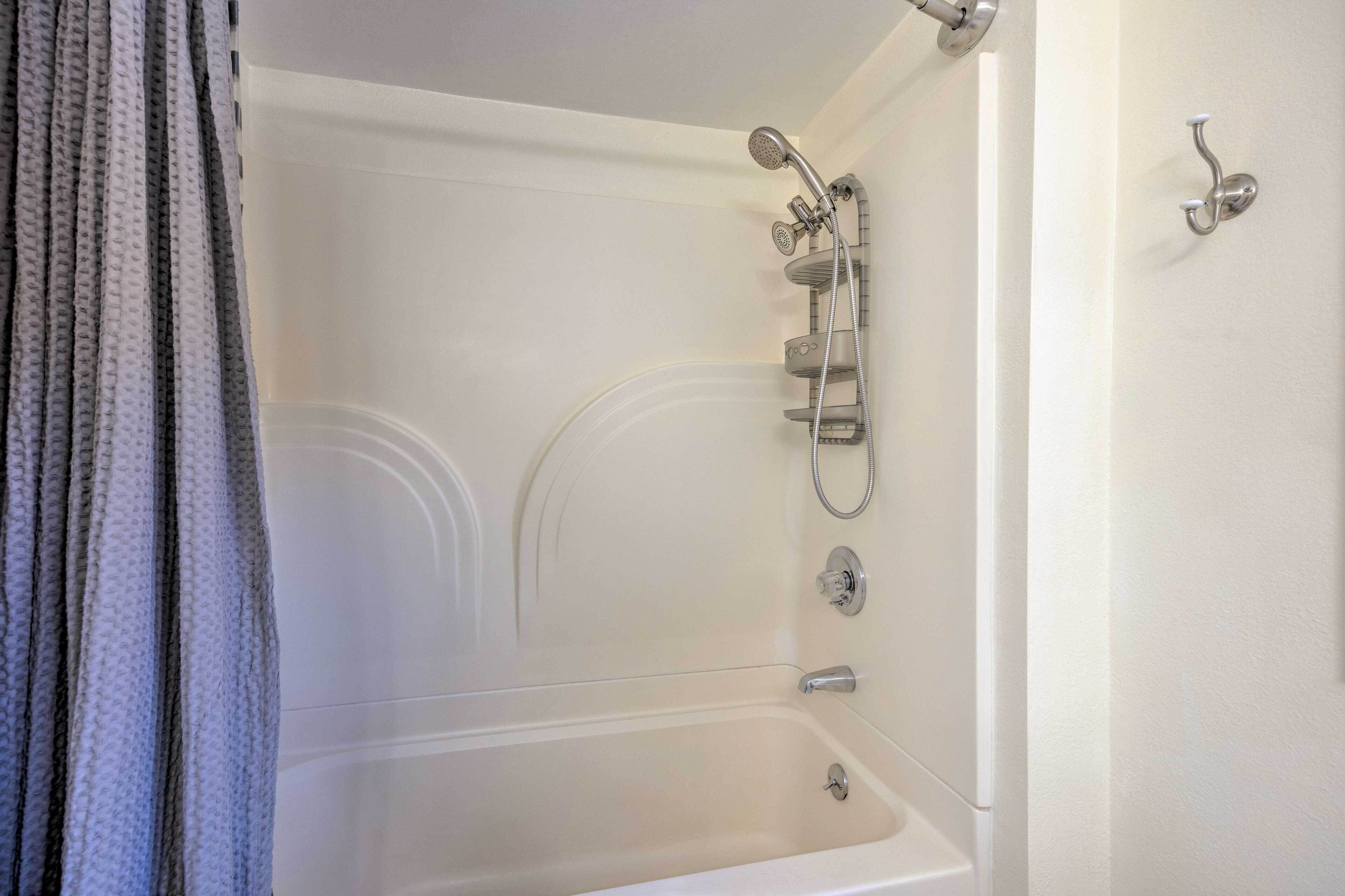 Un baño moderno con bañera, ducha y toallero.