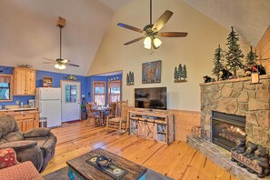 Una sala de estar acogedora con chimenea, muebles de madera y televisión.