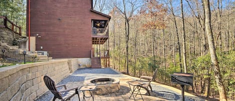A rustic cabin with a stone fire pit and outdoor seating.