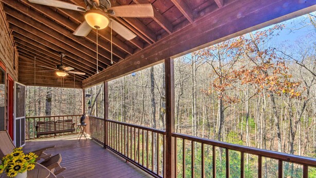 A wooden deck with a railing, a table with chairs, and a bench.