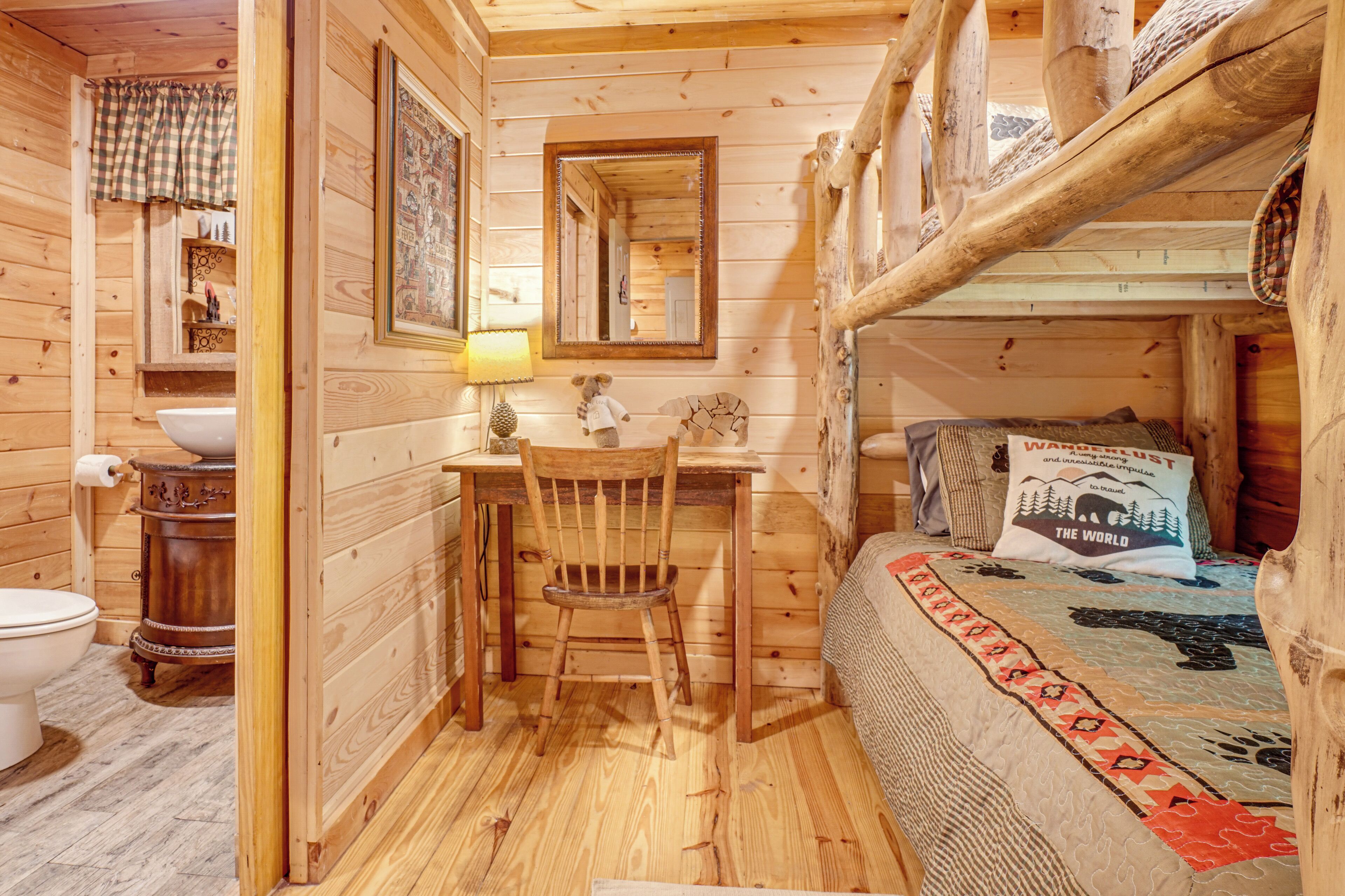 L'intérieur d'une cabane en bois, avec un bureau, une chaise et un lit superposé, tous en bois.