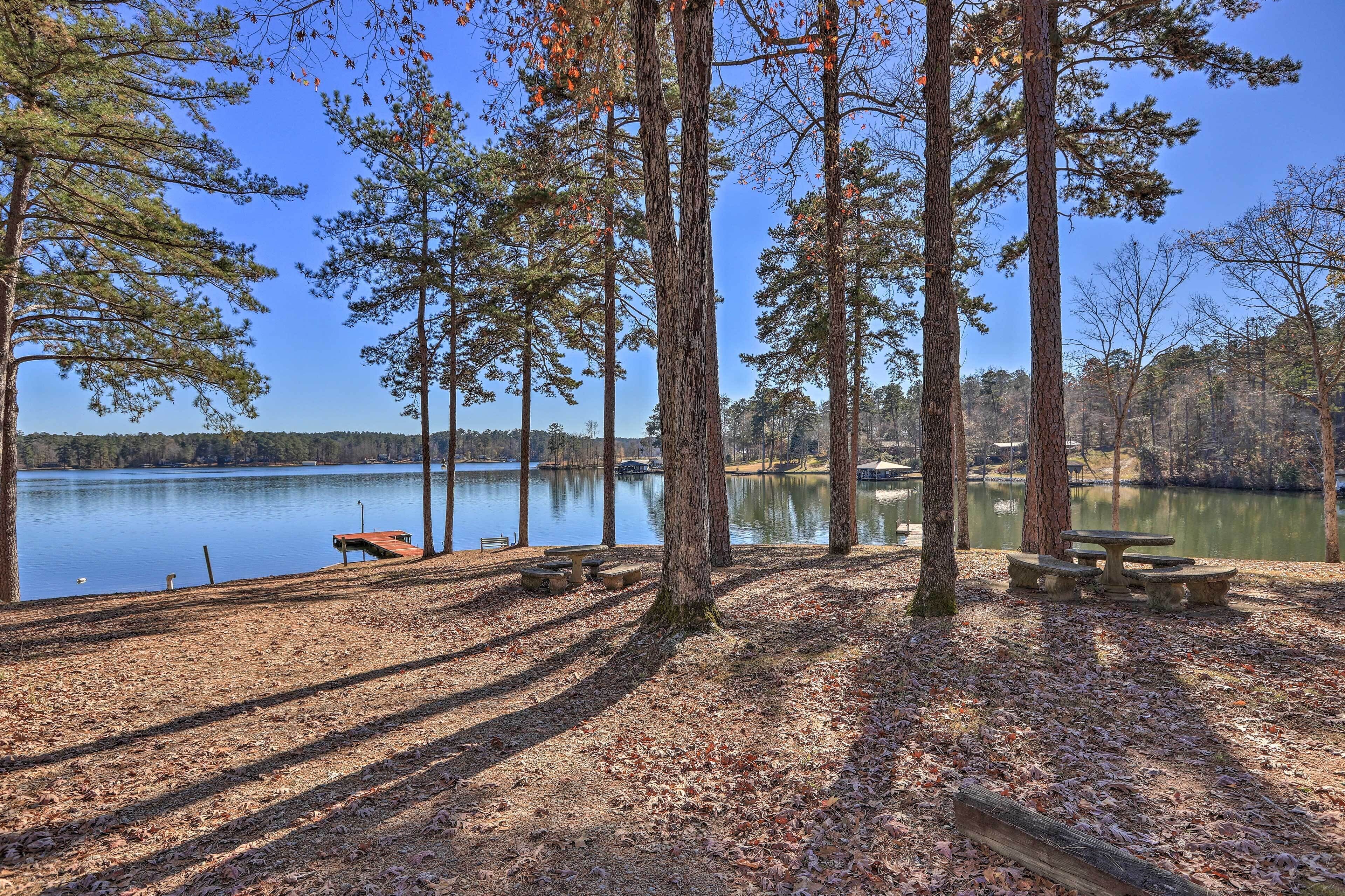 A lakeside picnic area with benches and a dock.