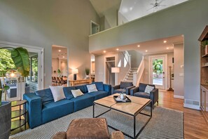 A spacious living room with a sectional sofa, a coffee table, and a staircase leading to an upper level. - Luxe Big Canoe Resort Home w/ 3 Decks & Mtn Views! (Dawsonville)