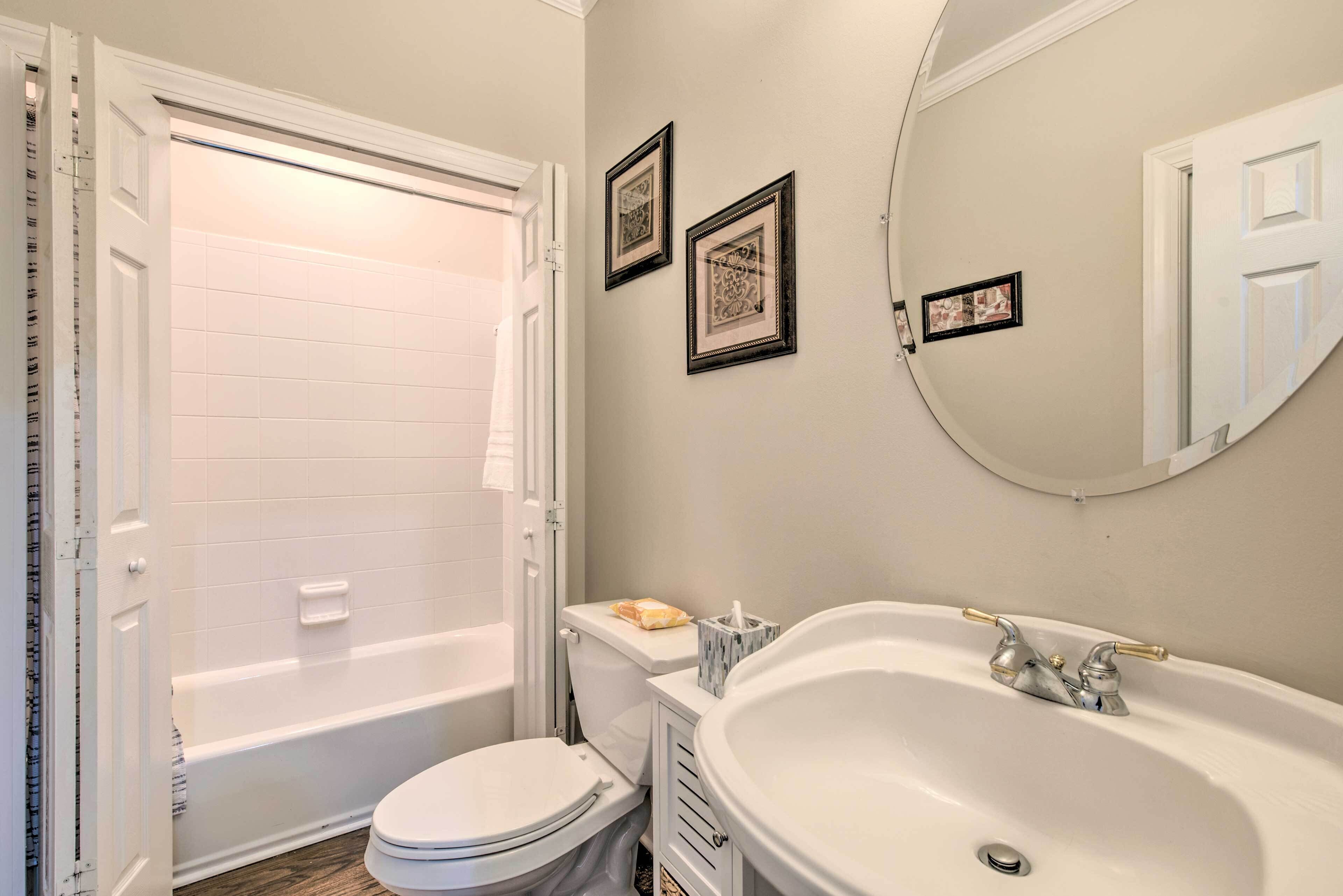 Une salle de bain équipée d’une baignoire, de toilettes, d’un lavabo et d’un miroir.