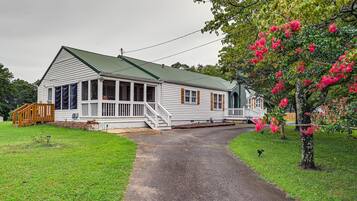 A two-story house with a porch, a covered front porch area, and a driveway leading to the house.