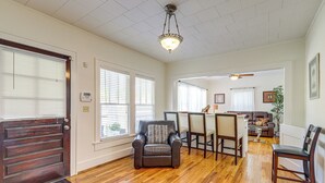 A spacious living room with hardwood flooring, a dark brown leather armchair, a dining area with a table and chairs, and a ceiling fan. - Main Street Home: 1 Mi to Callaway Gardens (Pine Mountain)