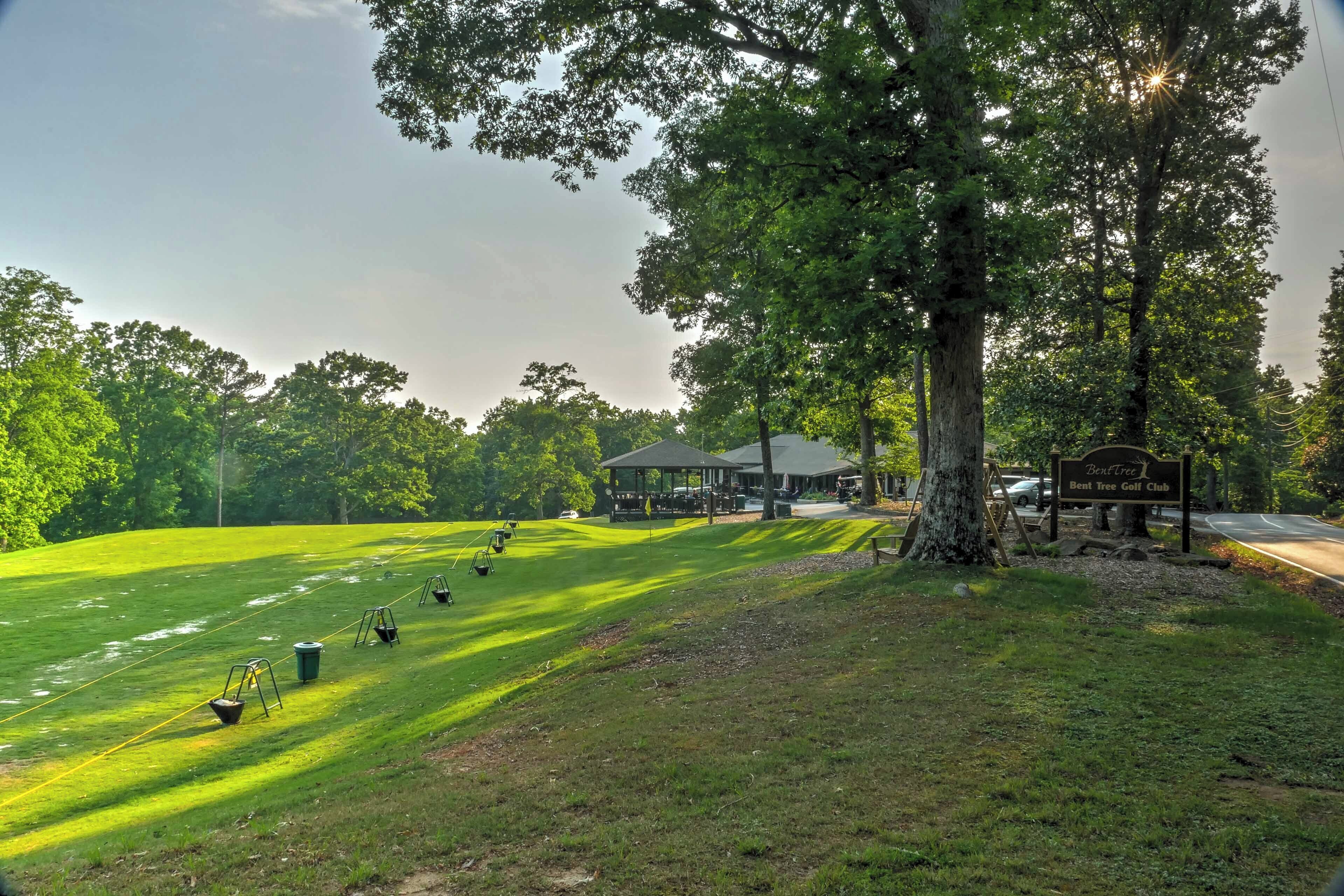 Un campo de golf con un club de campo, un árbol grande y un cartel que dice "Bent Tree Golf Club".