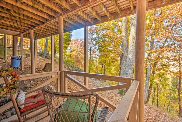 A wooden gazebo with a view of autumn foliage.