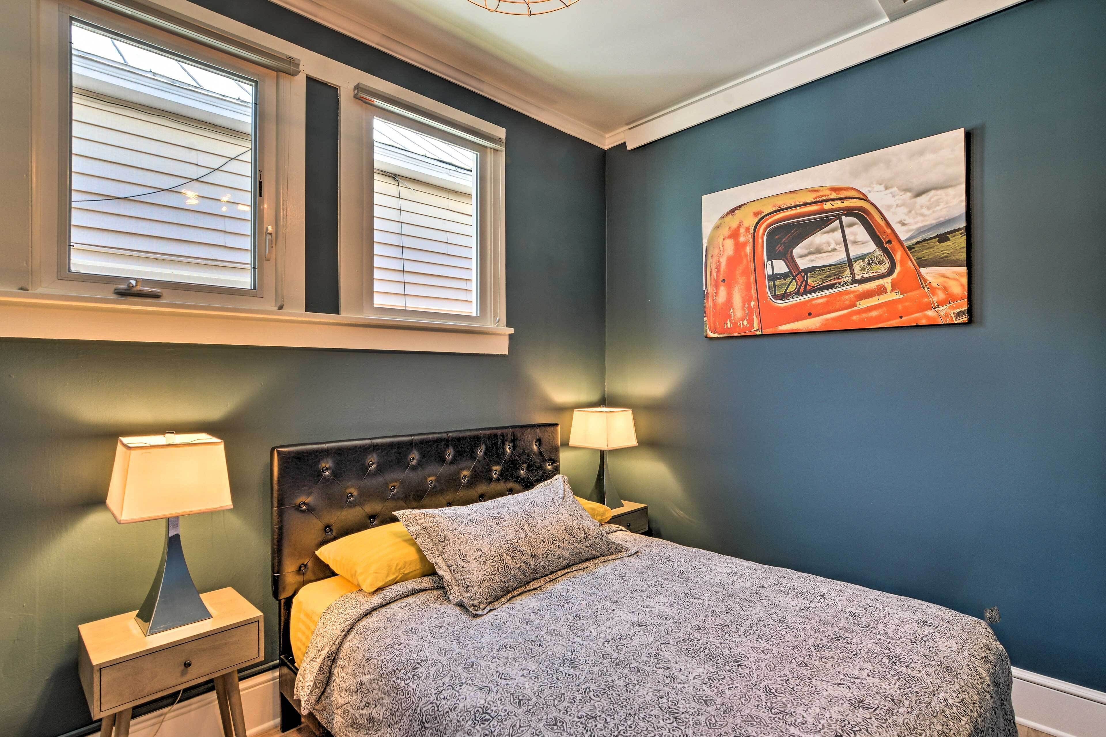 Une chambre à coucher avec un lit, deux lampes de chevet, une tête de lit et un tableau représentant un camion accroché au mur.