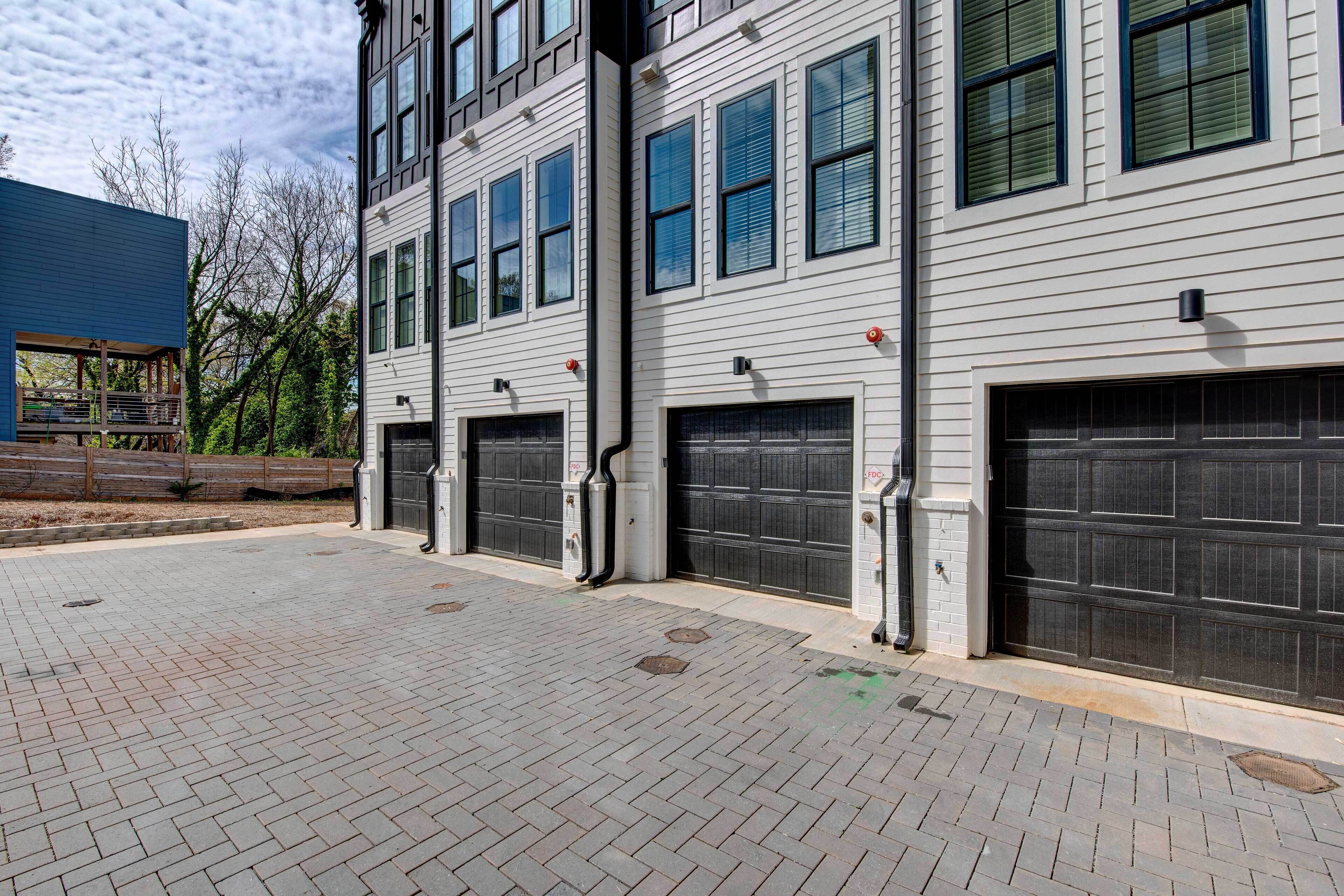 A building with three garage doors and a paved driveway.