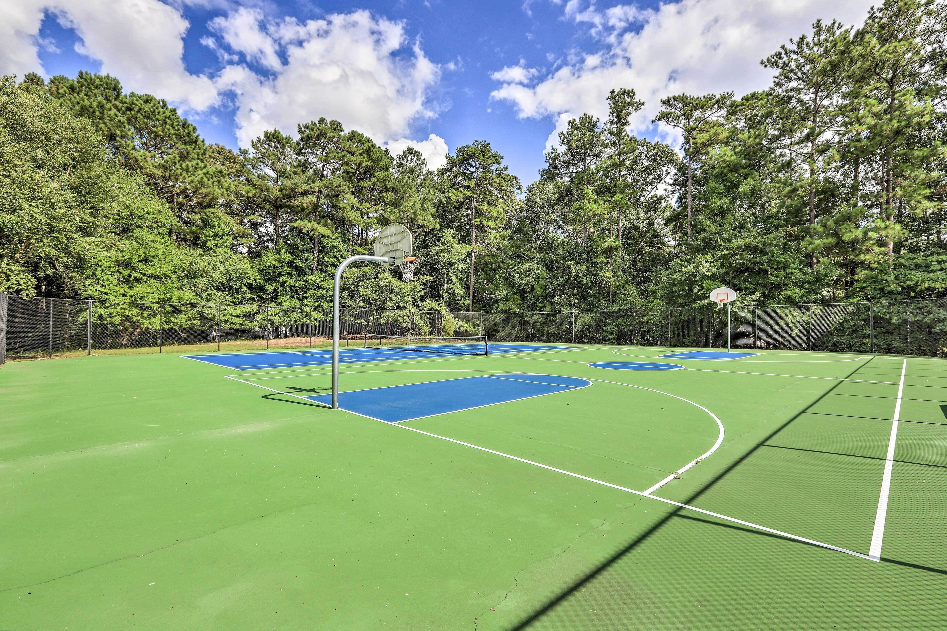 An outdoor basketball court surrounded by trees.