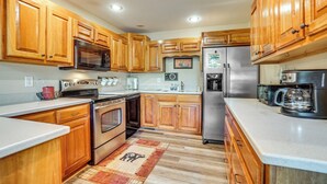 A kitchen with wooden cabinets, stainless steel appliances, and a central island. - Hiawassee Cabin < 10 Mi to Lake Chatuge! (Hiawassee)