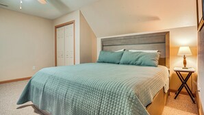 A bedroom with a bed, a ceiling fan, a nightstand, and a lamp. - Hiawassee Cabin < 10 Mi to Lake Chatuge! (Hiawassee)