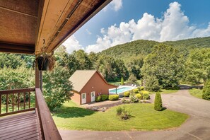 A wooden deck with a view of a house, a swimming pool, and a hilly landscape. - Hiawassee Cabin < 10 Mi to Lake Chatuge! (Hiawassee)