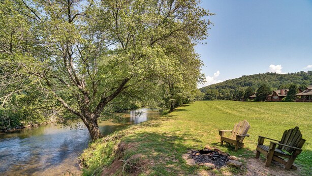 A riverside view with a large tree, a small fire pit, and two Adirondack chairs. - Hiawassee Cabin < 10 Mi to Lake Chatuge! (Hiawassee)