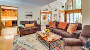 A spacious living room with two brown leather sofas, a wooden coffee table, and a colorful rug. - North Georgia Cabin w/ Hot Tub & Community Perks! (Jasper)