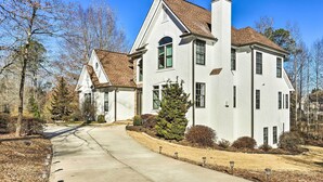 A two-story house with a prominent chimney, a large front porch, and a well-maintained lawn.