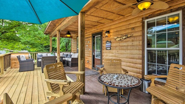 A wooden deck with outdoor furniture, including chairs and a table, and a ceiling fan.