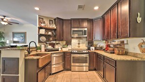 Una cocina con armarios de madera oscura, electrodomésticos de acero inoxidable y encimeras de granito.