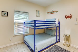 A bunk bed room with a window, a small rug, and wall decorations including a map and a crab. - Steps to Beach: Oceanside Townhome w/ Heated Pool (South Padre Island)