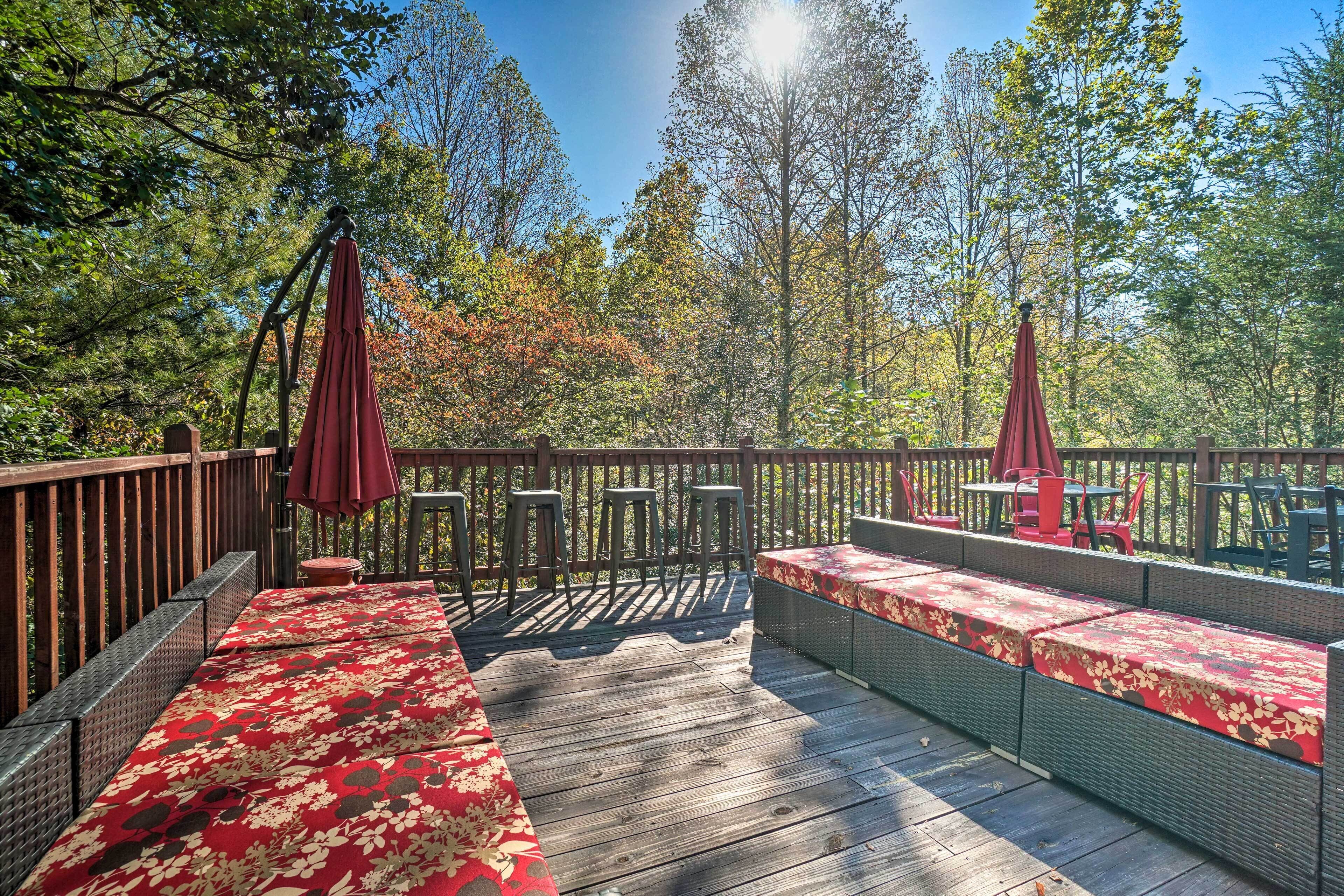 A wooden deck with outdoor seating and a view of trees.