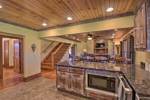 A spacious kitchen with a granite countertop, wooden cabinets, and a built-in oven. - Clarkesville Ranch Cabin w/ Screened-in Porch! (Clarkesville)