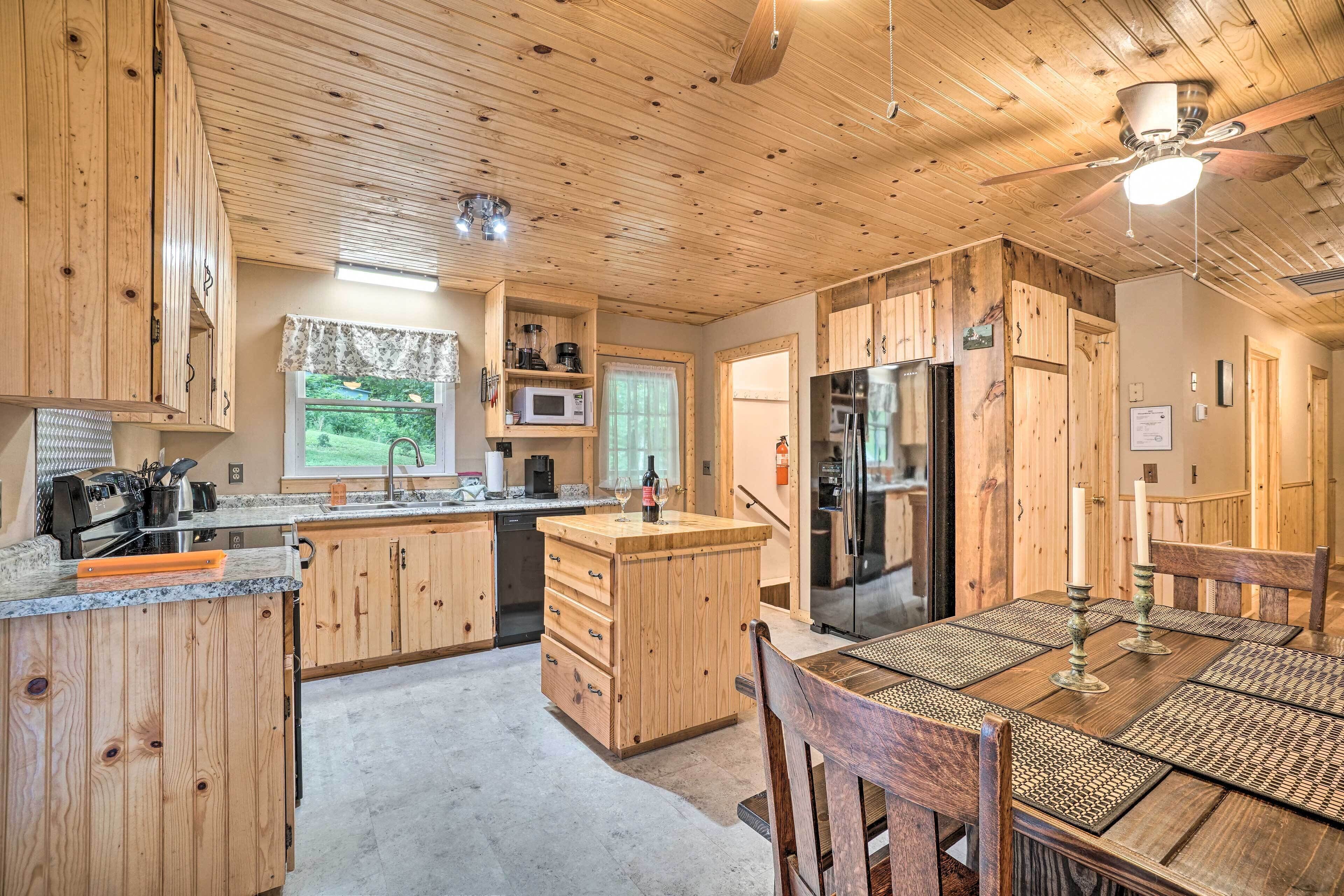 A wooden kitchen with a central island, built-in appliances, and a dining area with a table and chairs.
