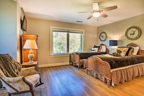A bedroom with a wooden bed, a chair, a desk, and a window with a view of trees. - Spacious Home + Acreage, 16 Mi to Chattanooga (Chickamauga)