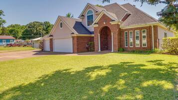 A single-story house with a brick exterior, a garage, and a well-maintained lawn.